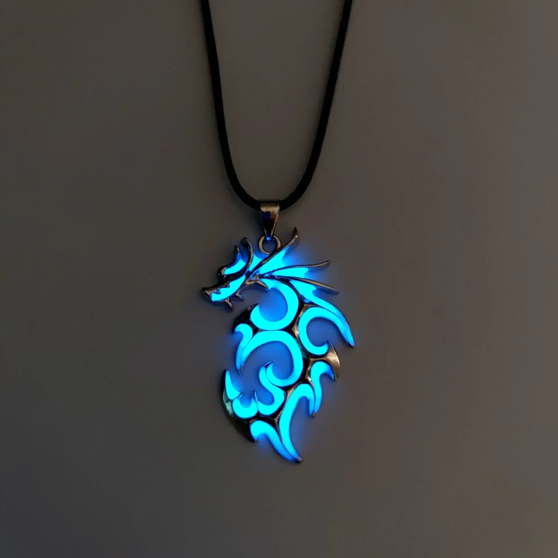 Glowing blue dragon pendant necklace with black cord, metallic finish, tribal design