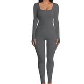 Woman wearing fitted gray ribbed long sleeve jumpsuit with square neckline