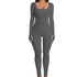 Woman wearing fitted gray ribbed long sleeve jumpsuit with square neckline
