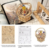 Wooden mechanical model kit with gears and orbits, colorful beads, DIY assembly instructions shown.