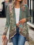 Woman wearing a green floral patterned open-front cardigan with long sleeves, paired with blue jeans and a white crop top, showcasing casual streetwear style.