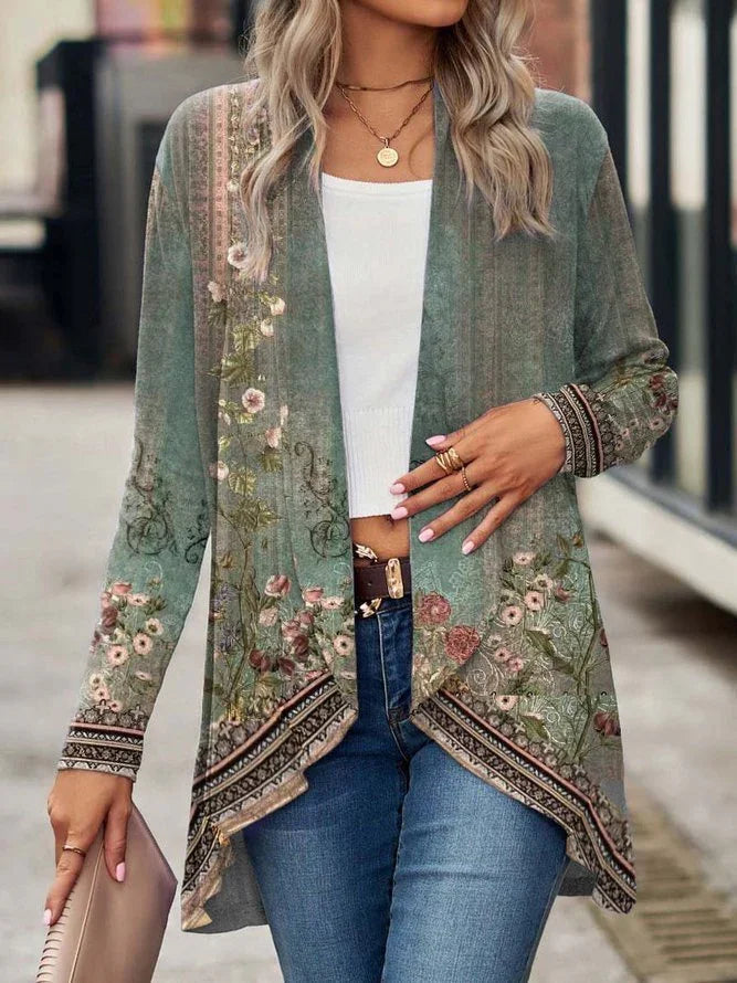 Woman wearing a green floral patterned open-front cardigan with long sleeves, paired with blue jeans and a white crop top, showcasing casual streetwear style.