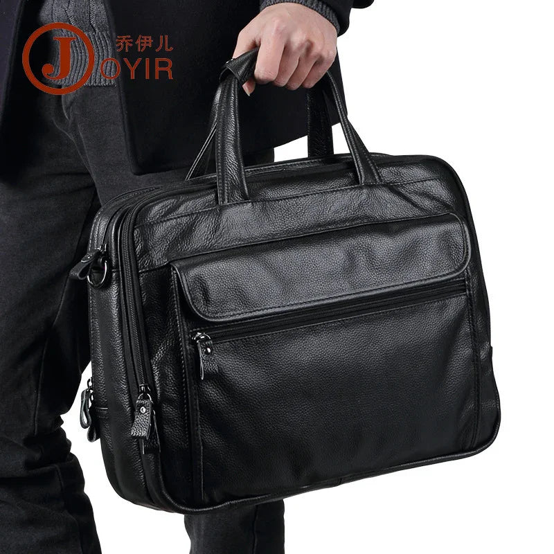 Man holding a black leather briefcase with zipper pockets, dressed in dark casual wear