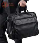 Man holding a black leather briefcase with zipper pockets, dressed in dark casual wear