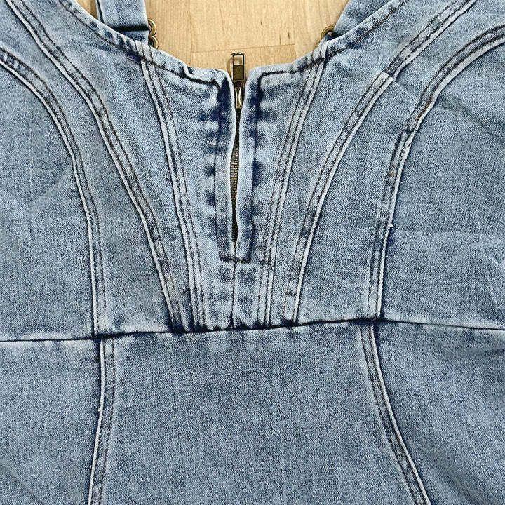 Light wash denim top with visible seam details, structured fit, and front zipper closure.
