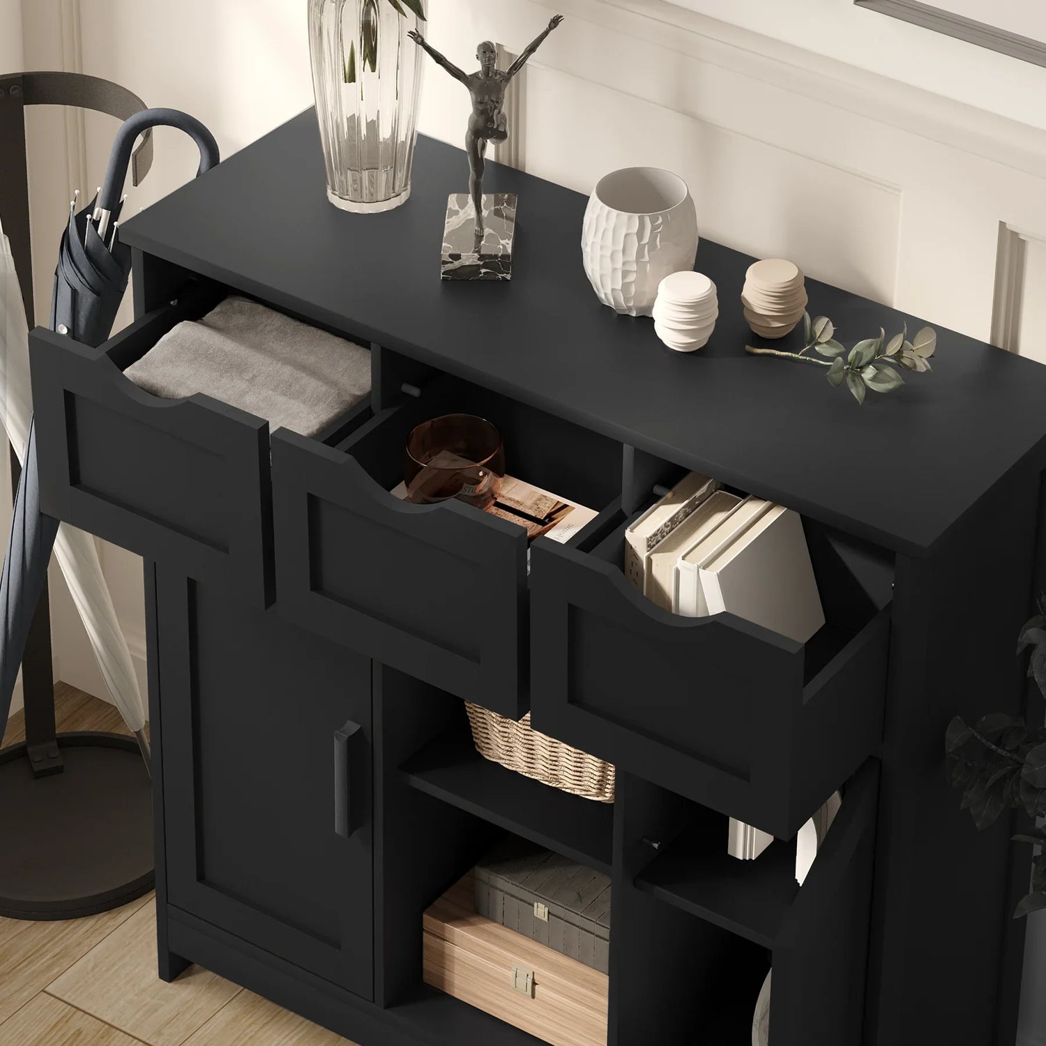 Modern black wooden storage cabinet with open drawers, books, and decorative items on top