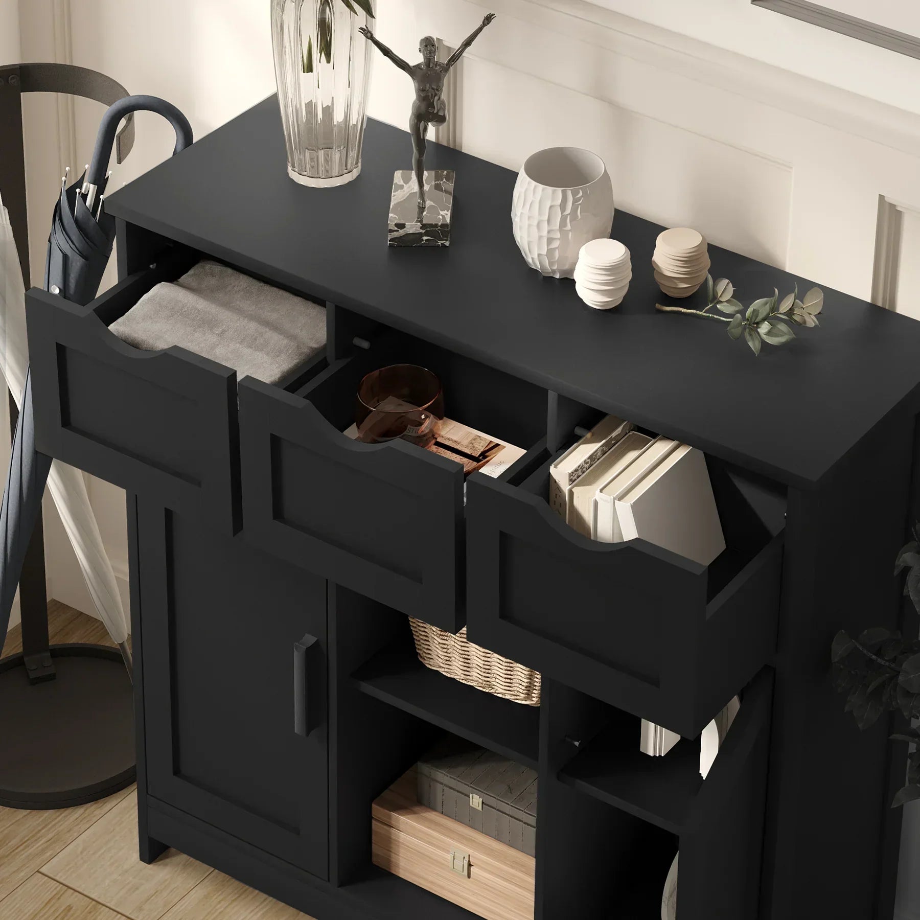 Modern black wooden storage cabinet with open drawers, books, and decorative items on top