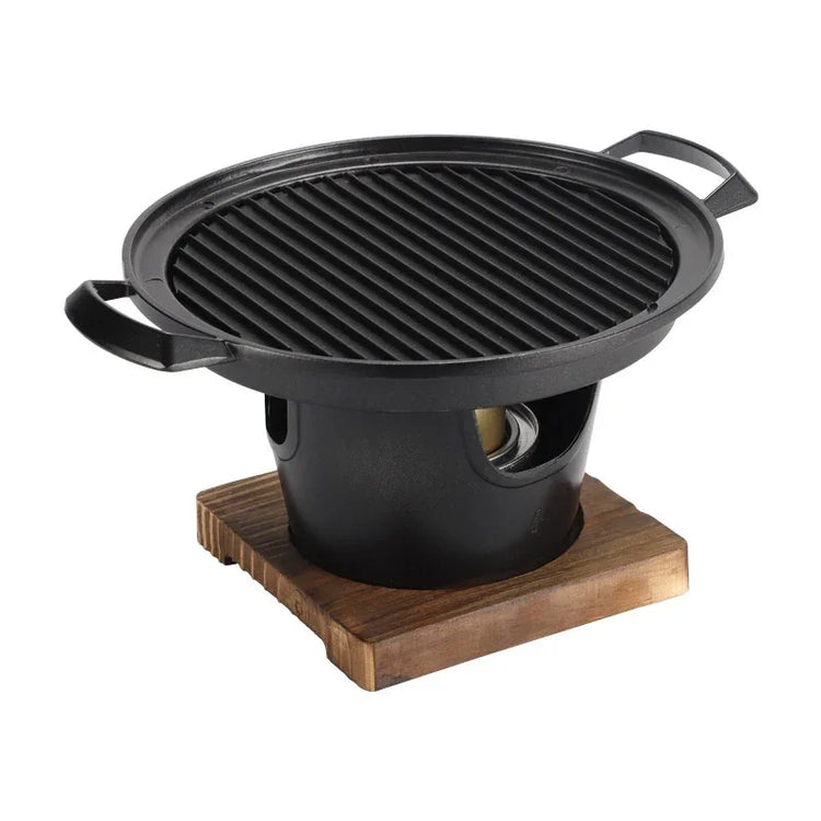 Round black cast iron tabletop grill with wooden base, modern minimalist design