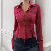 Fitted red pinstripe button-up shirt with long sleeves and collared neckline, paired with black jeans.