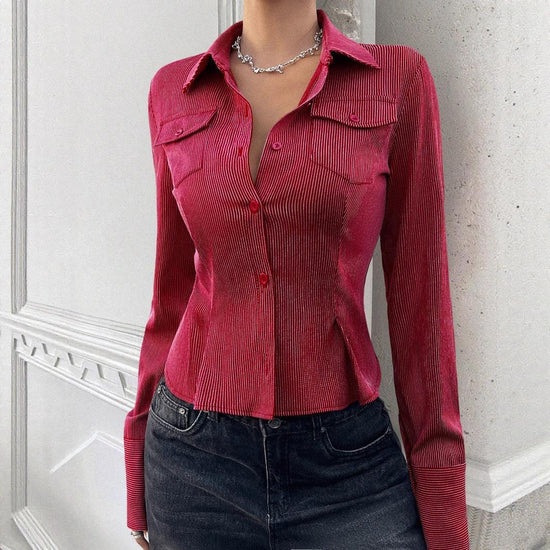 Fitted red pinstripe button-up shirt with long sleeves and collared neckline, paired with black jeans.