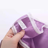 Purple cotton garment with white lace trim, close-up showing care label and soft fabric