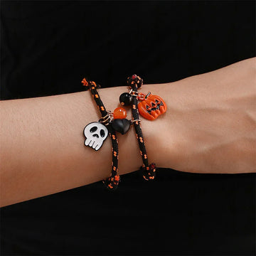 Black and orange cord bracelets with skull, pumpkin, and bead charms, Halloween style.