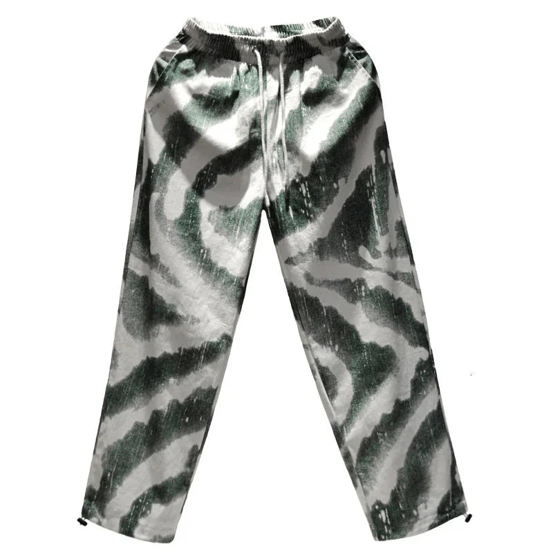 Loose fit green and white abstract print jogger pants with elastic waistband, streetwear style