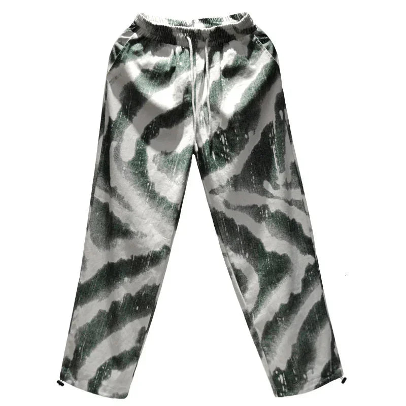 Loose fit green and white abstract print jogger pants with elastic waistband, streetwear style