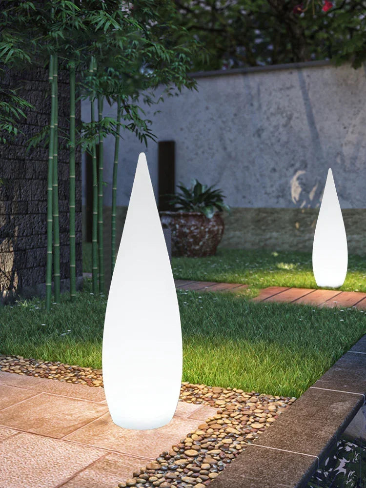 Modern white cone LED garden lights on stone path in outdoor setting, surrounded by greenery