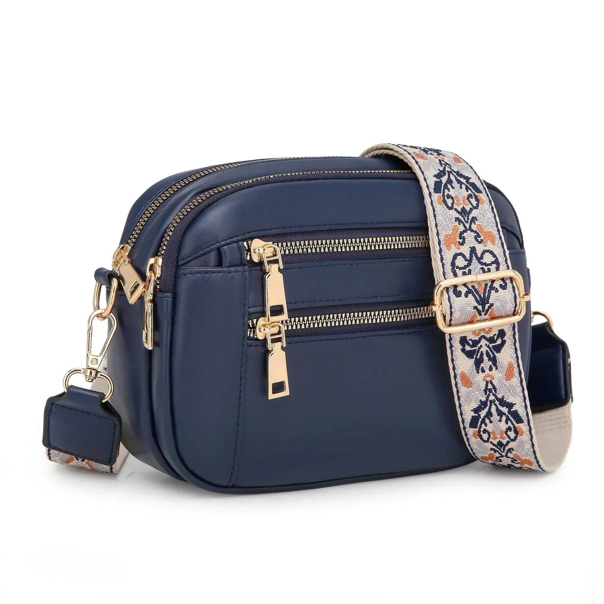 Navy blue faux leather crossbody bag with gold zippers and patterned adjustable strap