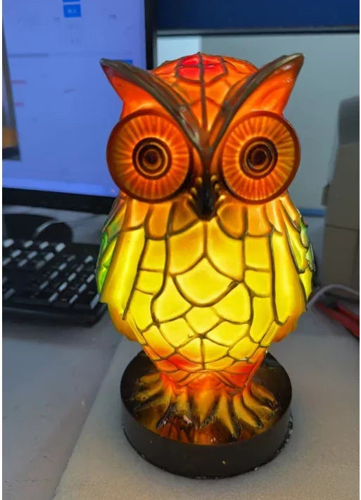 Colorful stained glass owl lamp with bright yellow and orange body, on desk setting