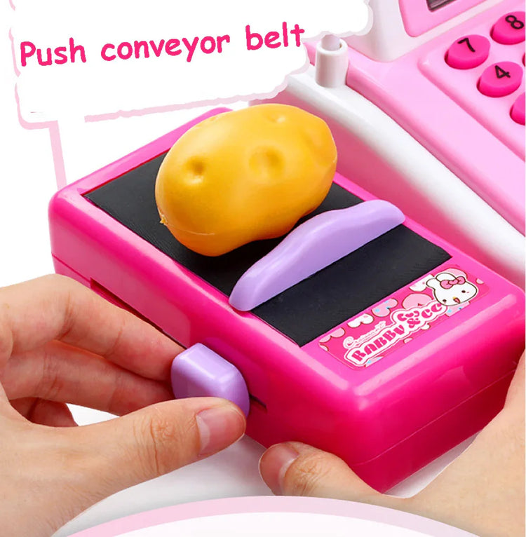 Pink plastic toy cash register with a conveyor belt and yellow pretend potato