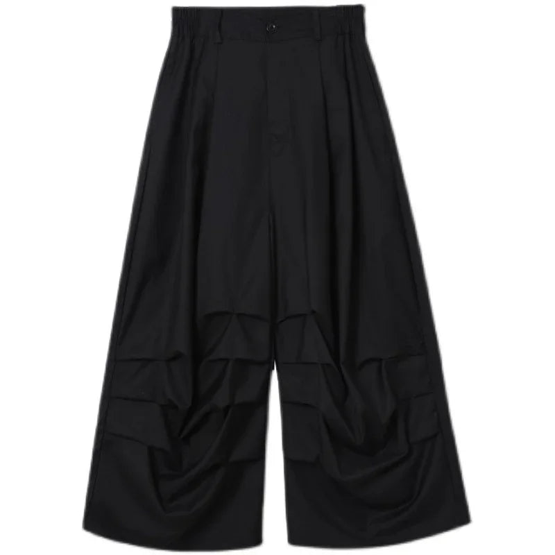 Wide-leg black pants with draped details, loose fit, futuristic streetwear style
