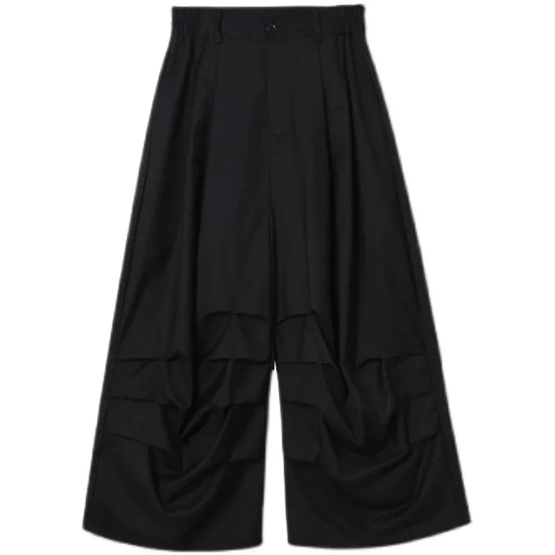 Wide-leg black pants with draped details, loose fit, futuristic streetwear style
