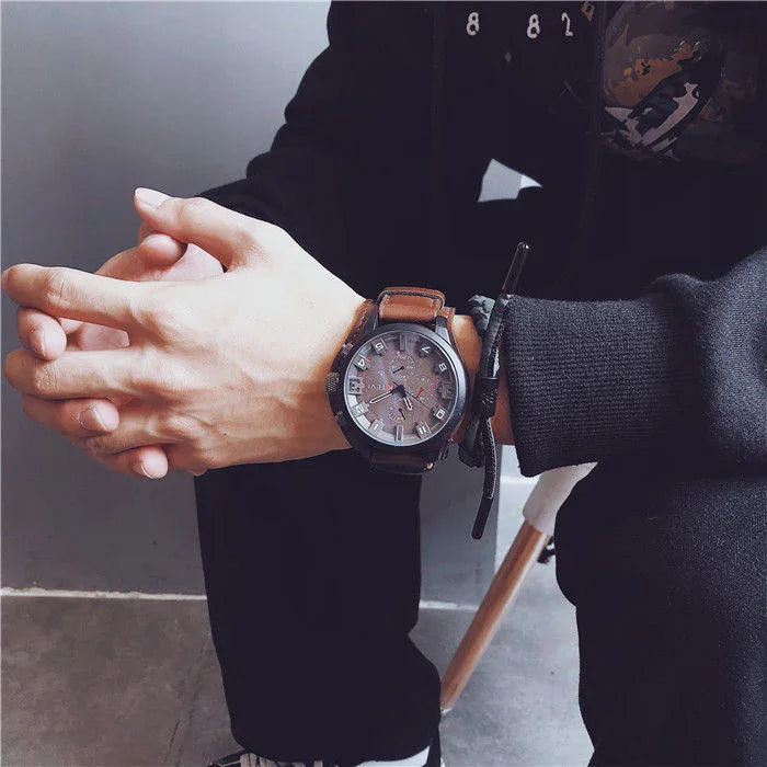 Man wearing black streetwear hoodie and pants, brown leather strap watch, casual fit