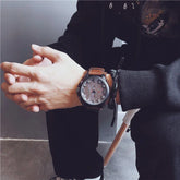 Man wearing black streetwear hoodie and pants, brown leather strap watch, casual fit