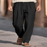 Man wearing black pleated wide-leg trousers with relaxed fit and lightweight fabric