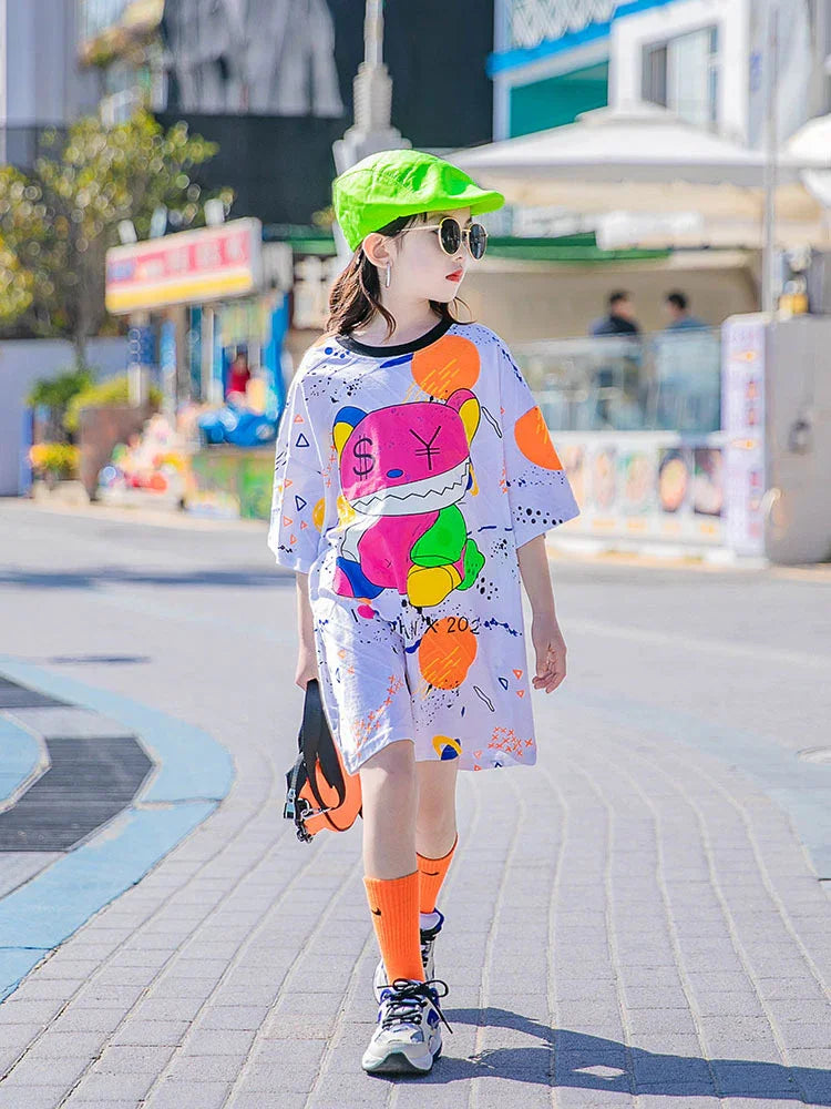 Girl wearing oversized white graphic t-shirt dress, neon green cap, orange socks, street style