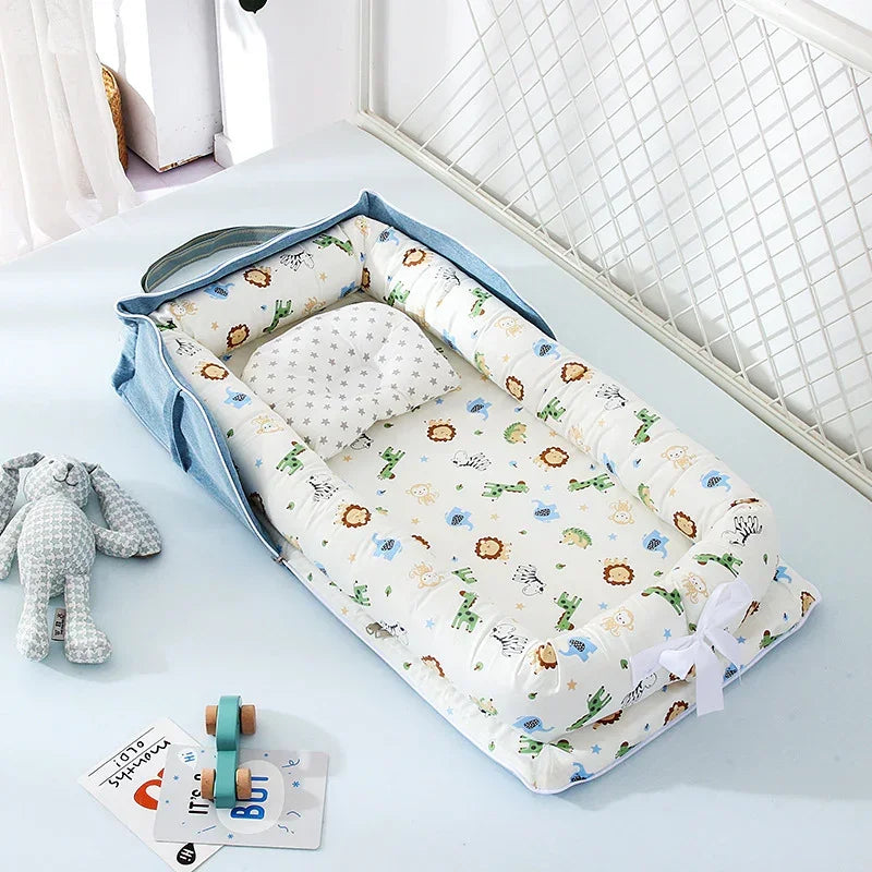 Soft baby nest with colorful animal print, padded sides, and matching pillow in a light nursery setting.