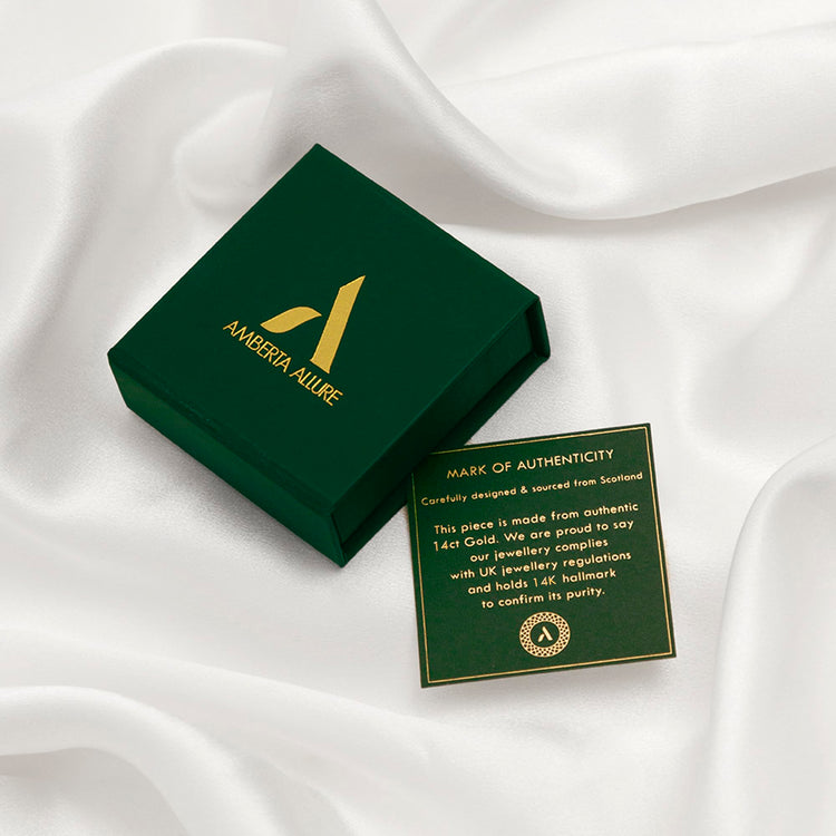Amberta Solid Italian 14K gold wedding band box with authenticity card on white silk background