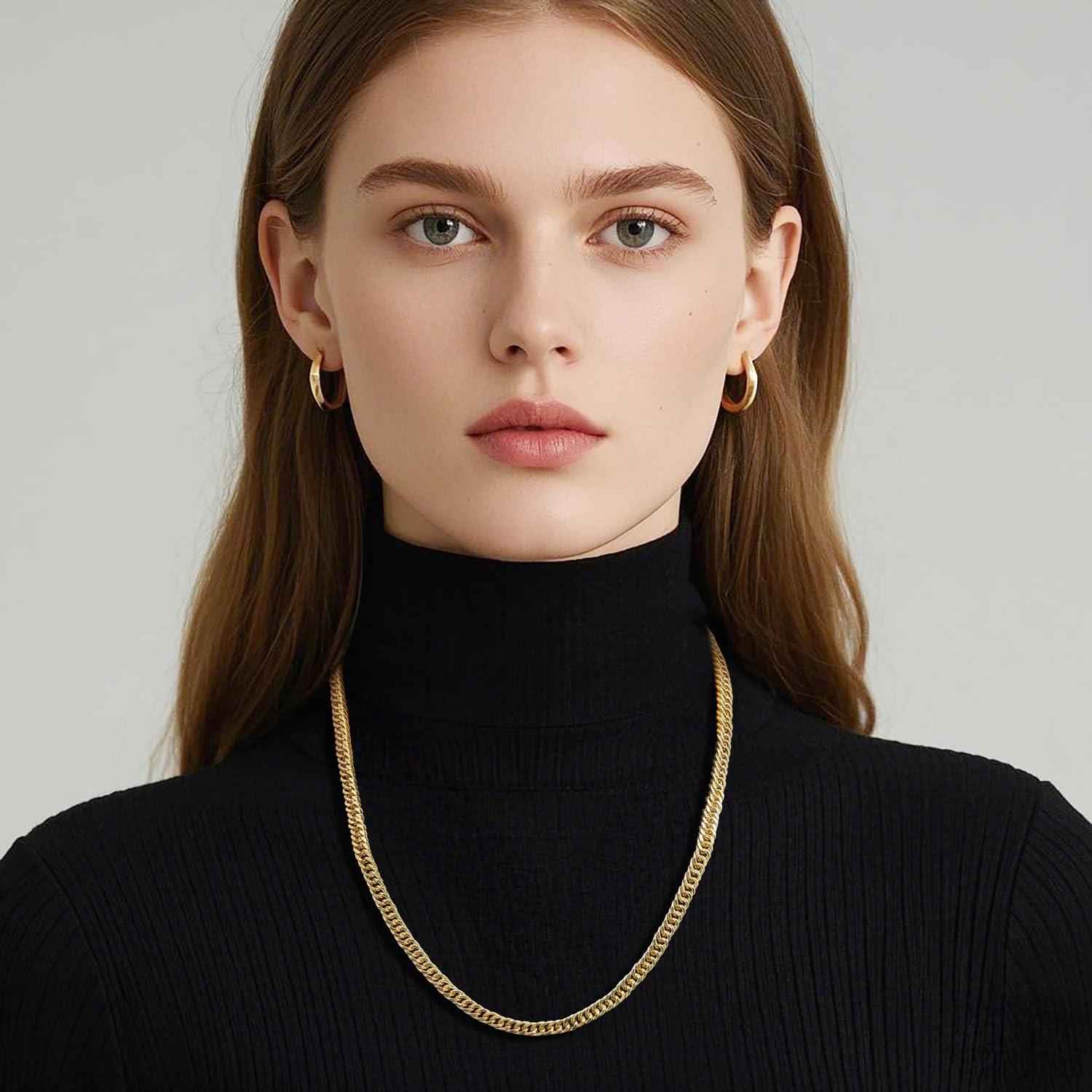 Woman wearing a 14K gold Cuban link chain necklace with chunky, engraved links and a black turtleneck