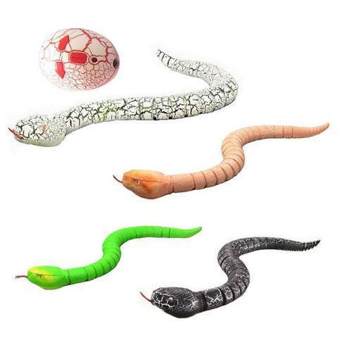 Colorful realistic rubber snake toys in white, orange, green, and black with an egg-shaped accessory