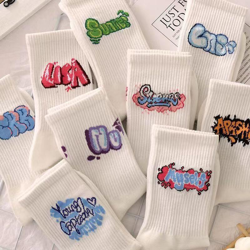 White ribbed crew socks with colorful graffiti-style embroidered text, streetwear fashion