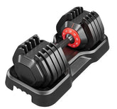 Adjustable black dumbbell with red weight dial in plastic tray, modern gym accessory