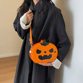 Woman in loose black coat holding orange pumpkin-shaped crossbody bag, autumn streetwear