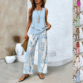 Woman wearing light blue sleeveless blouse and wide-leg leaf print pants, casual summer outfit.