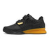 Black athletic sneaker with yellow honeycomb sole, dual strap closure, and low-top fit