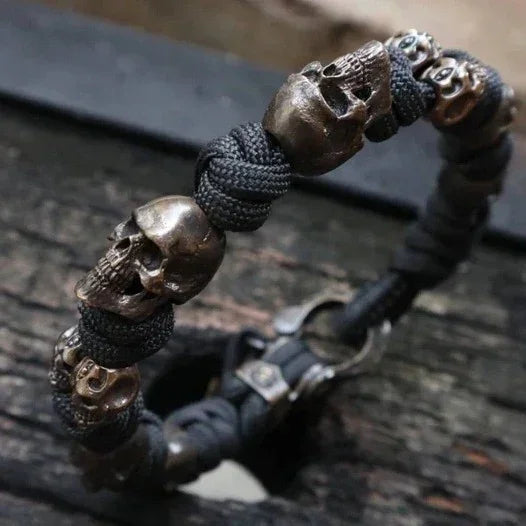 Black paracord bracelet with metallic skull beads, rugged streetwear accessory, adjustable fit