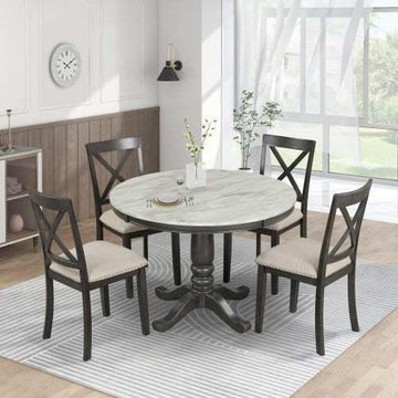 Modern dining room with round marble table and four dark wood upholstered chairs on a striped rug
