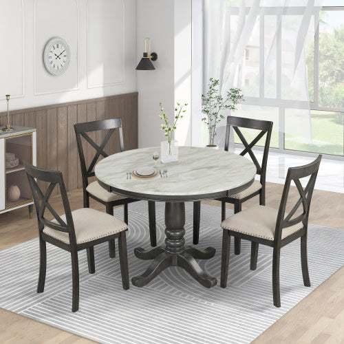 Modern dining room with a round marble-top table and four dark wood chairs with beige upholstered seats, set on a striped rug in a bright, airy space.