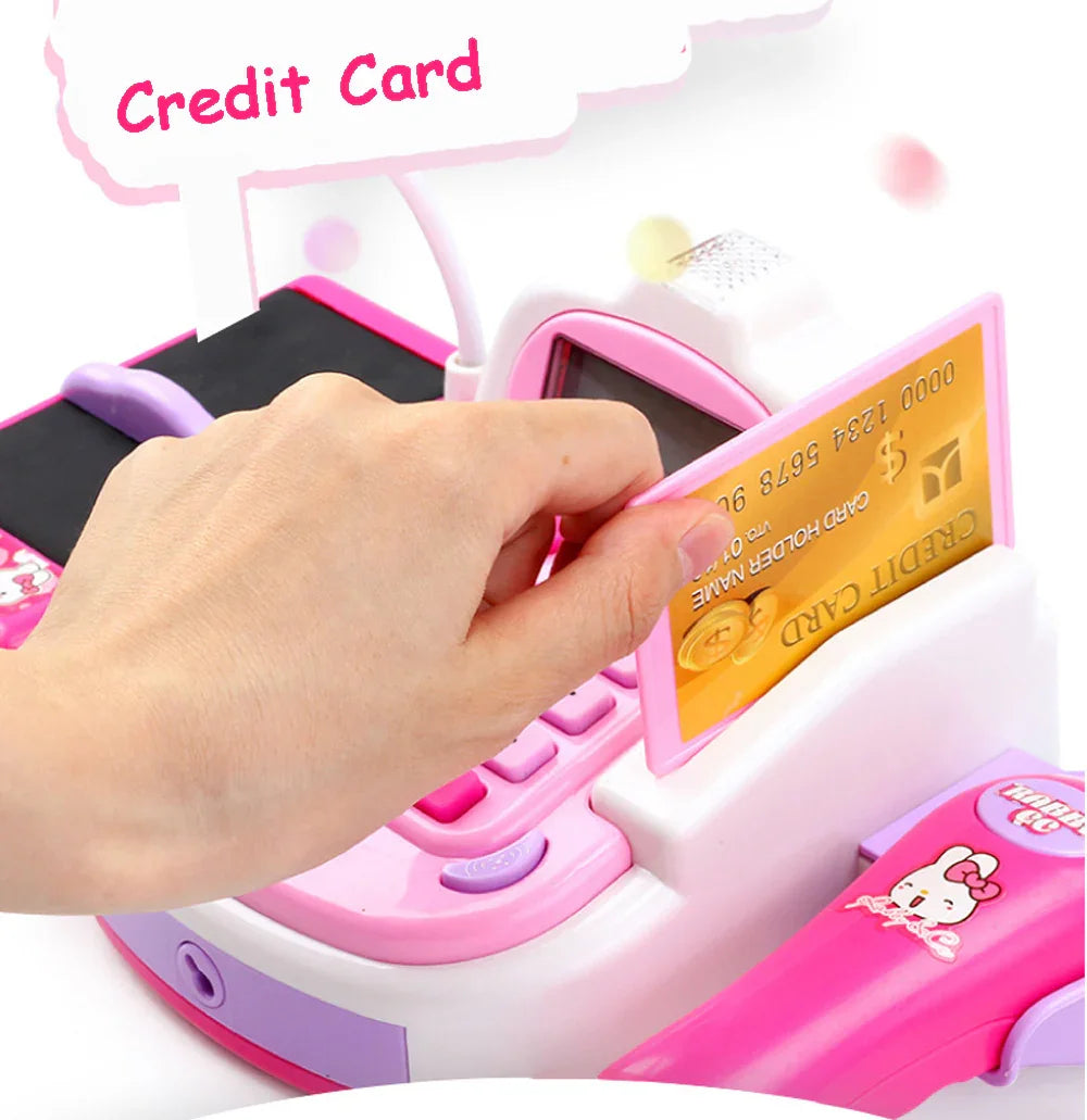 Hand swiping toy credit card through pink and white plastic toy cash register