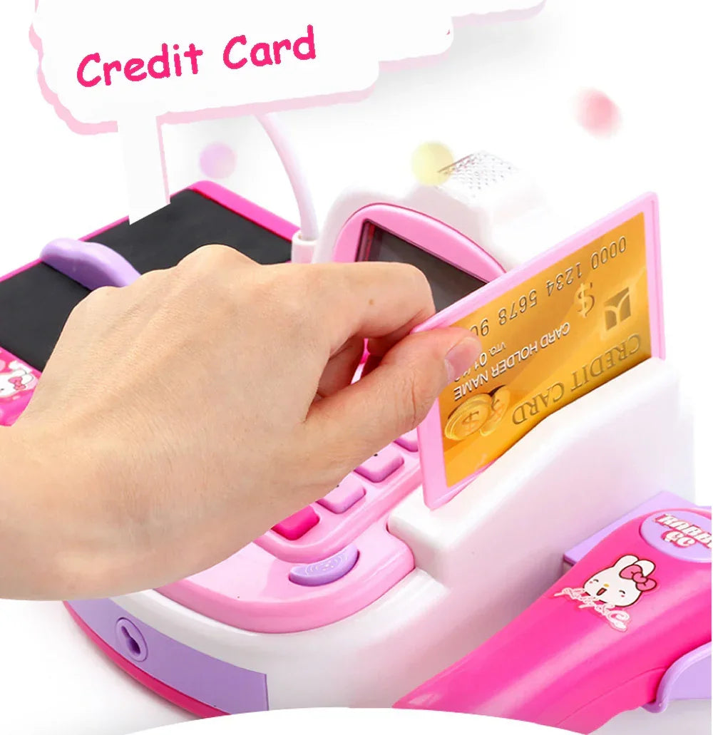 Hand swiping toy credit card through pink and white plastic toy cash register