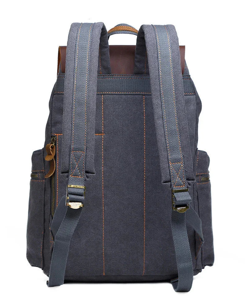 Dark grey canvas backpack with adjustable padded straps and brown stitching, rear view