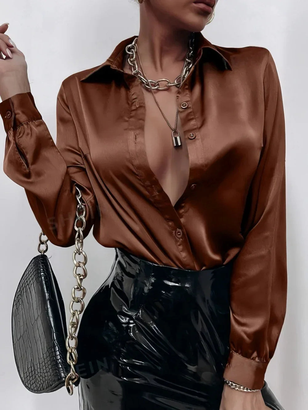 Brown satin long sleeve shirt with deep neckline, black patent leather skirt, trendy fit
