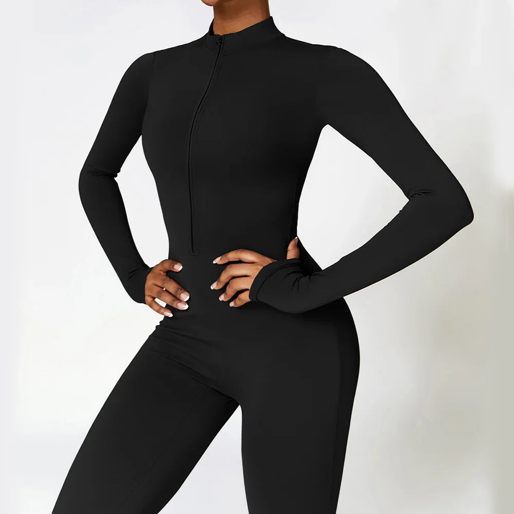 Woman wearing a black fitted long sleeve jumpsuit with zip front and high neckline