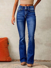 High-waisted blue flared denim jeans with slim fit and front button detail