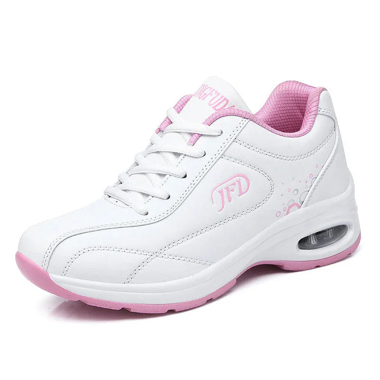 White and pink leather sneaker with lace-up closure, cushioned sole, and breathable mesh lining
