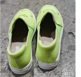 Lime green slip-on canvas shoes with cartoon face print, white soles, casual streetwear style