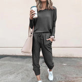 Woman in dark grey casual jogger set, relaxed fit, soft material, street style outfit