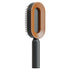 Modern oval hairbrush with brown and black body, ergonomic handle, and spaced bristles